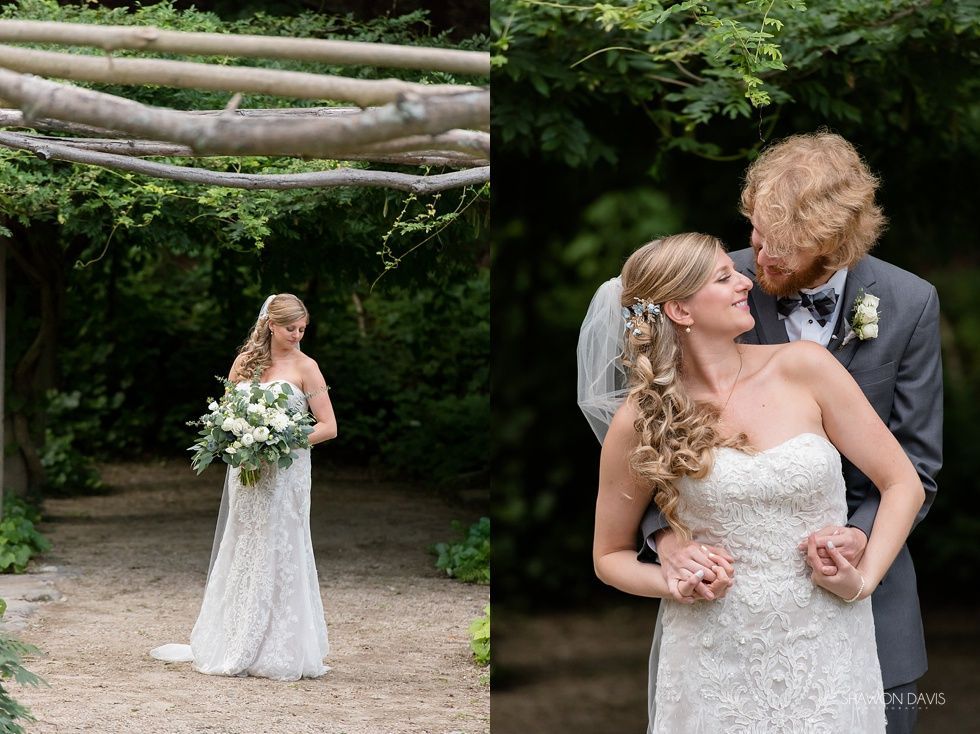 Bride in strapless lace gown kissing groom in suit at outdoor wedding ceremony, bouquet in hand