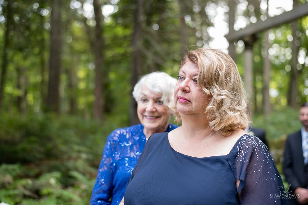 Two women outdoors at a park, one in a blue dress and one in a navy top, smiling.