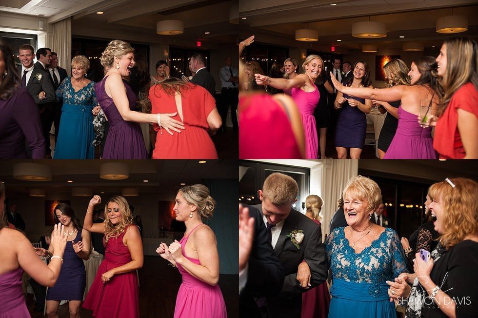 Guests in formalwear dancing and laughing at a lively indoor reception