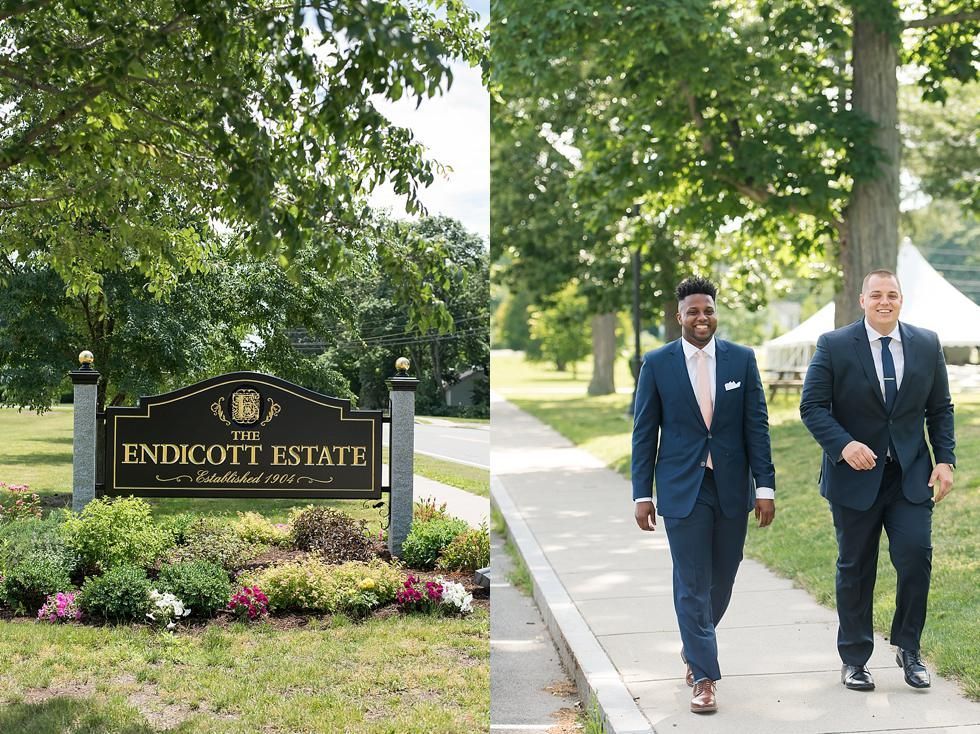 Two men in suits walking on a sidewalk beside the Endicott Estate sign and trees