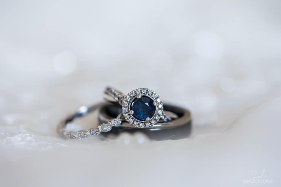 Silver rings with a blue gemstone and pavé accents on a soft blurred background