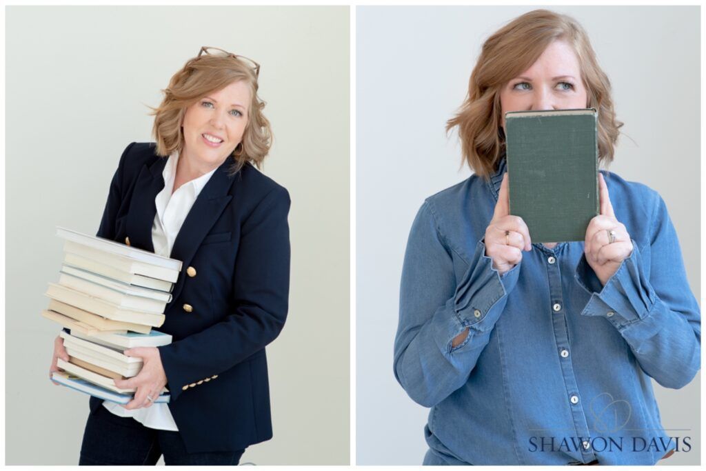 Two women in business attire holding stacks of books and a green book cover against a light background