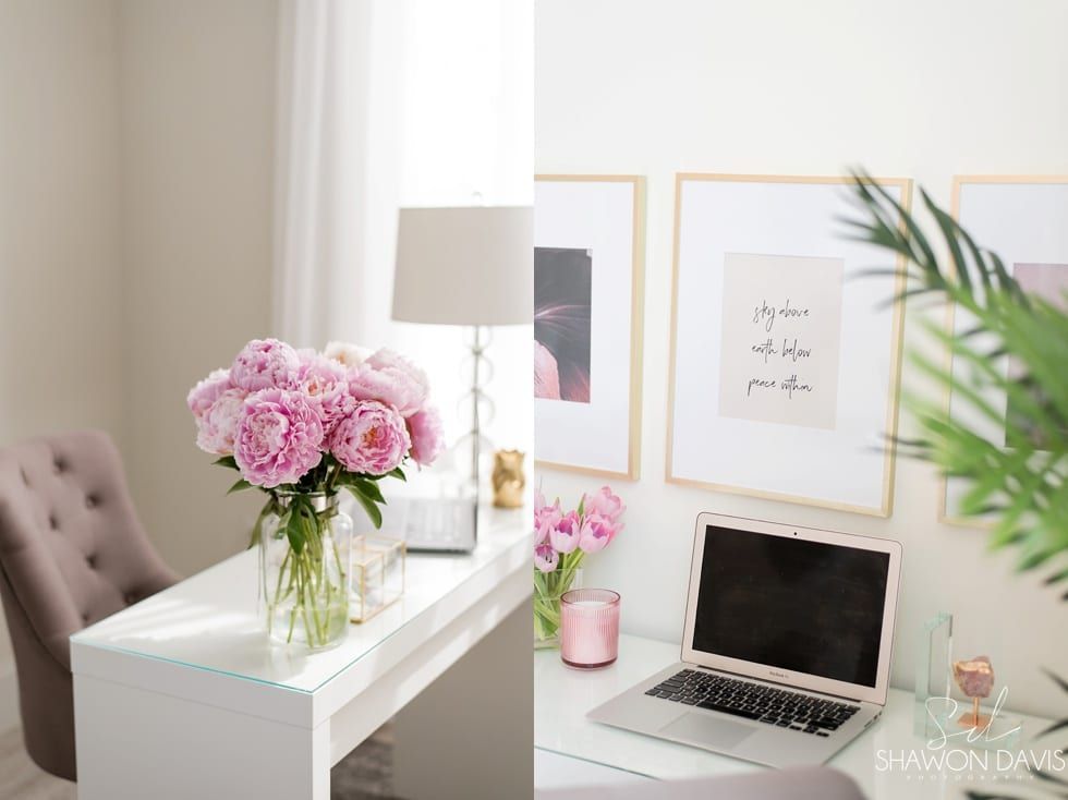 Bright white desk with laptop, pink flowers, and framed art in a soft home office setup