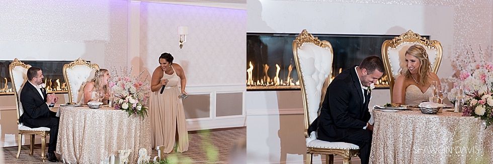 Elegant banquet hall with white and gold decor, a woman speaking at a podium, and guests seated at decorated tables