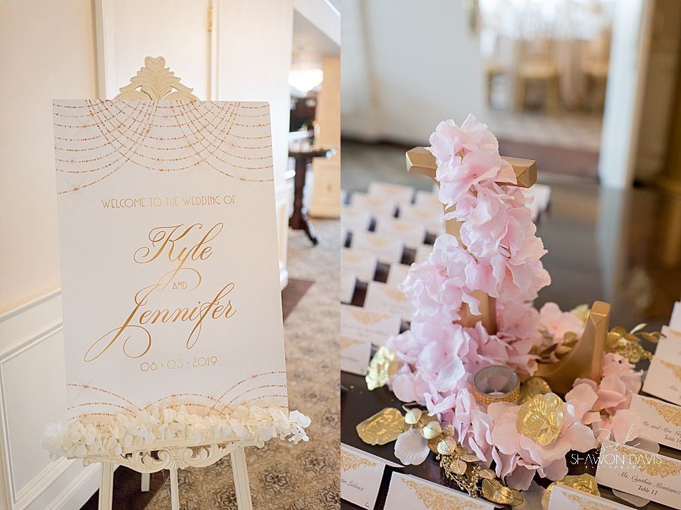 Elegant wedding seating sign on a lace easel beside pink flowers and place cards on a decorated table.