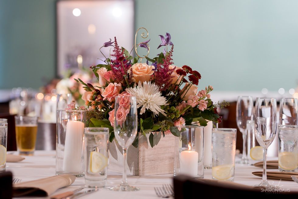 Elegant banquet table with a colorful floral centerpiece, candles, and glassware set for a formal event