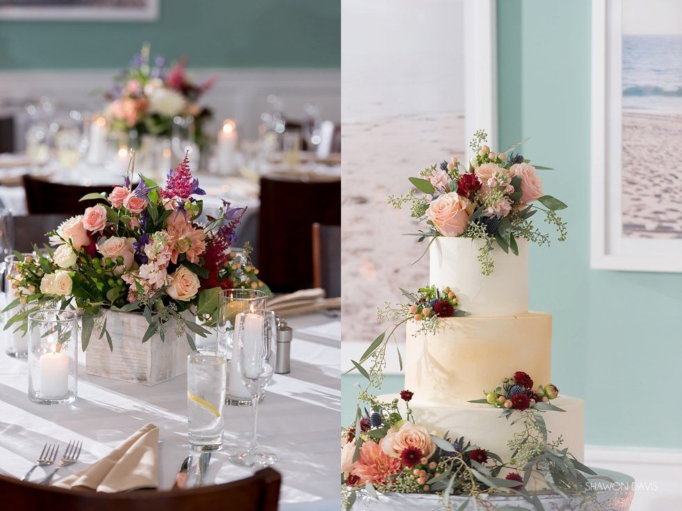 Elegant wedding reception table with pastel floral centerpieces, cake, and white table settings by the seaside