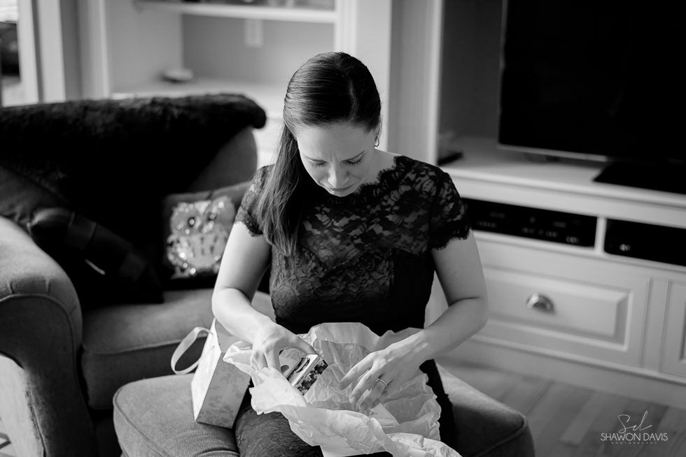 Woman holding a baby in a living room, looking down with a gentle smile