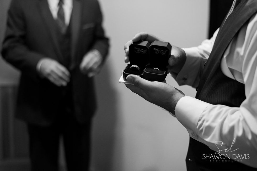 Photographer holding a DSLR camera while a blurred person stands in the background