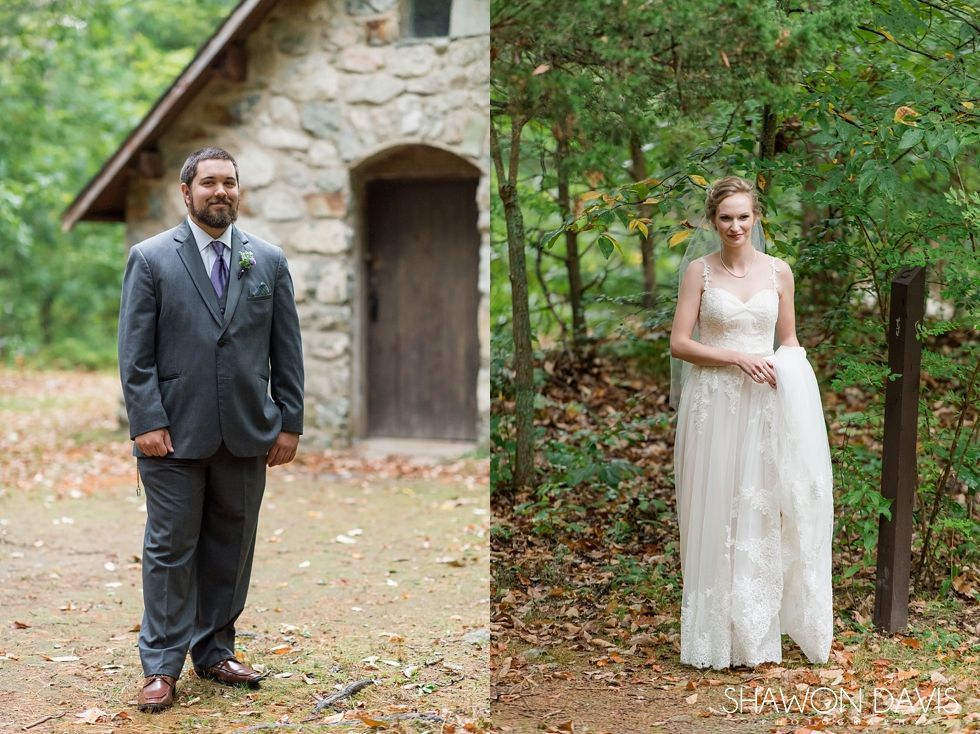 Bride and groom standing apart outdoors by a stone building, holding hands with a rustic garden backdrop