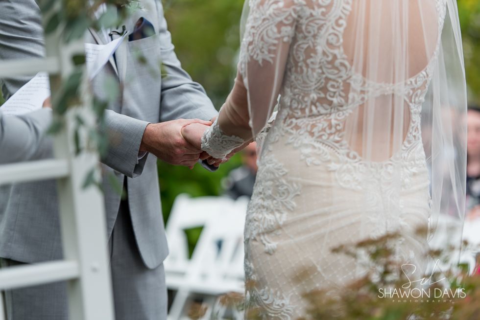 Bride and groom holding hands during a wedding ceremony outdoors