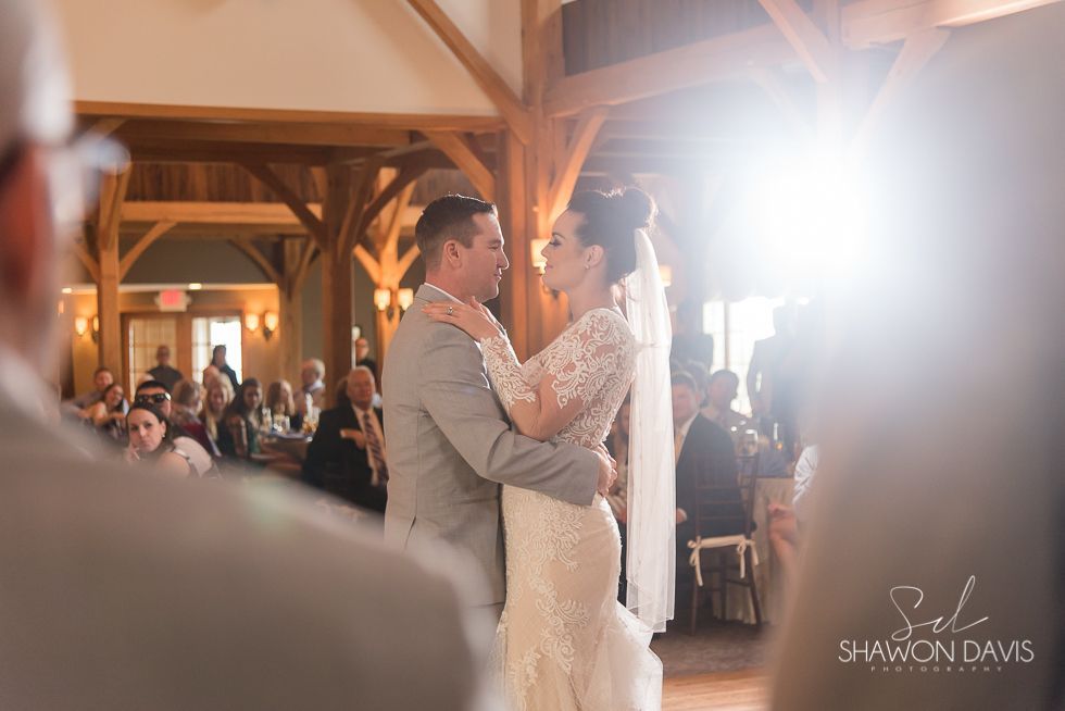 Bride and groom slow dancing at a warmly lit wedding reception