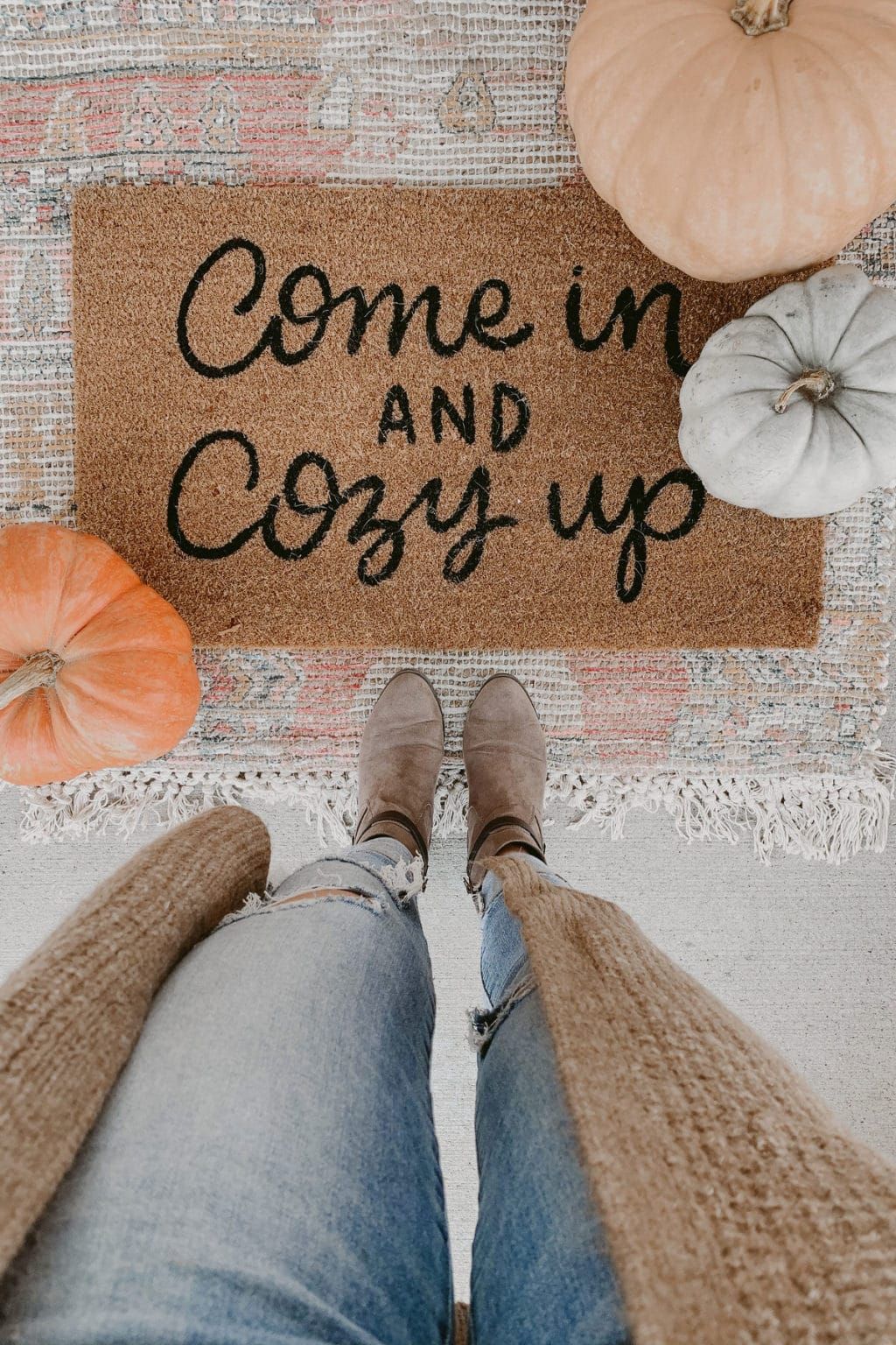Cozy fall doormat reading “Come in and Cozy up,” with pumpkins and boots on a textured rug