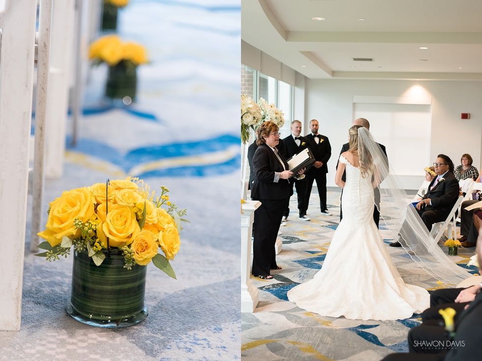 Bride and groom exchanging vows in a bright hallway with yellow flowers in the foreground