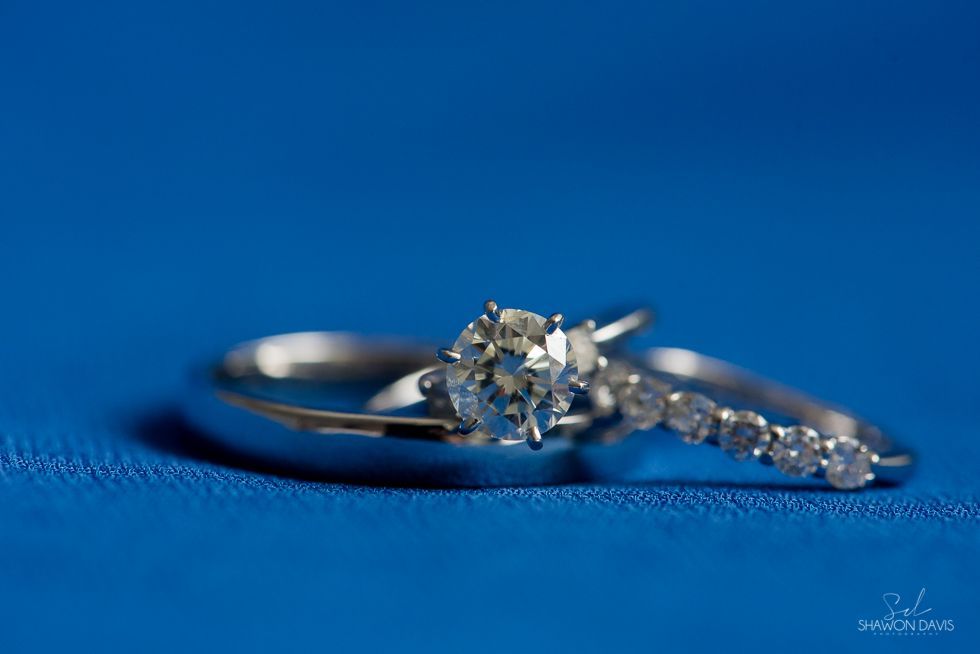 Diamond engagement ring on blue fabric with matching gemstone band