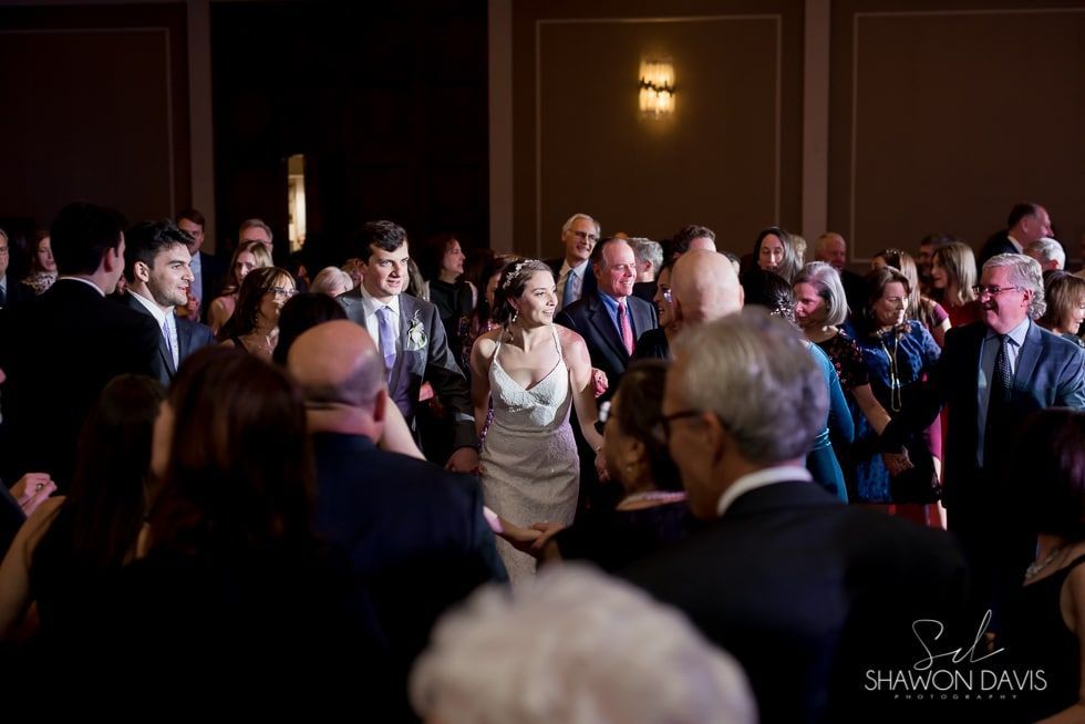 Audience standing and applauding in a dimly lit formal hall during an event