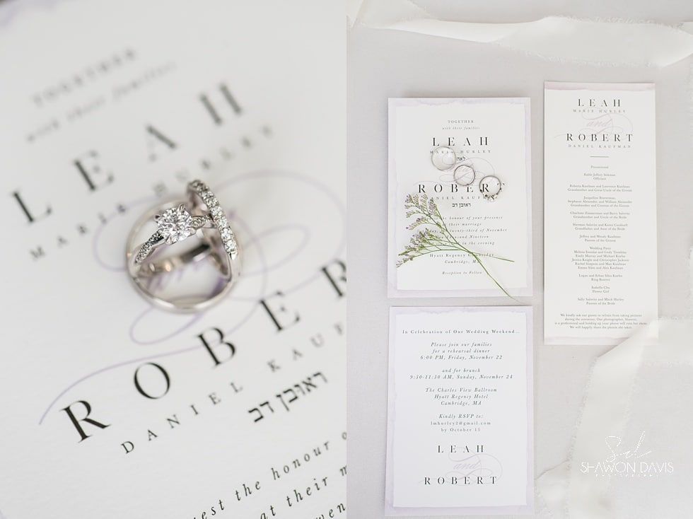 Wedding invitation suite with silver ring on a white fabric background