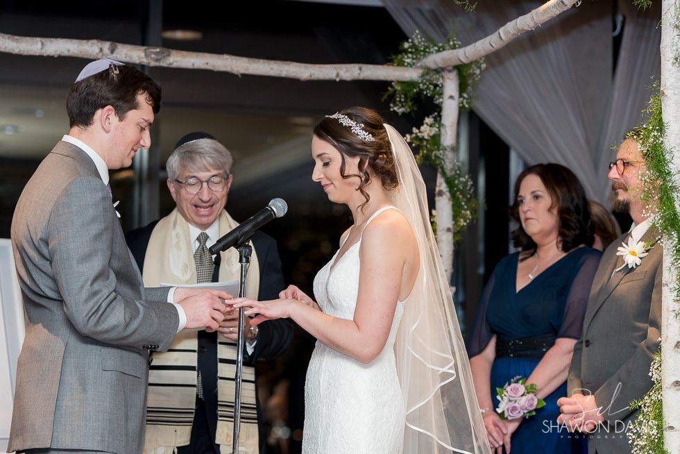 Wedding couple exchanging rings during an outdoor ceremony