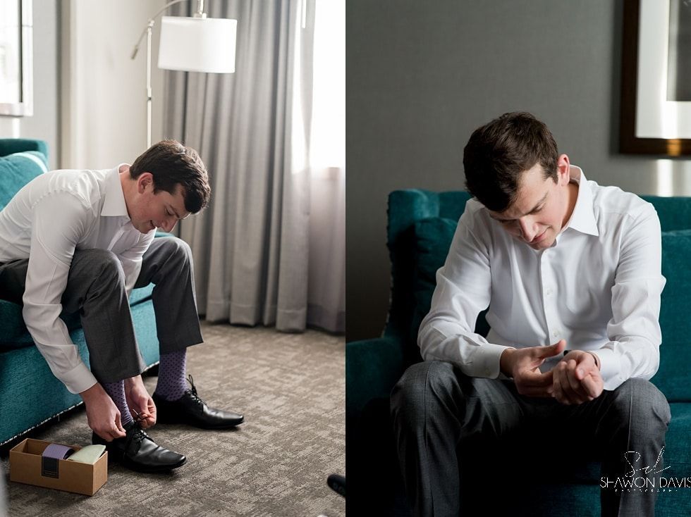 Man tying shoe on couch while another man sits on chair, head in hands, in a living room