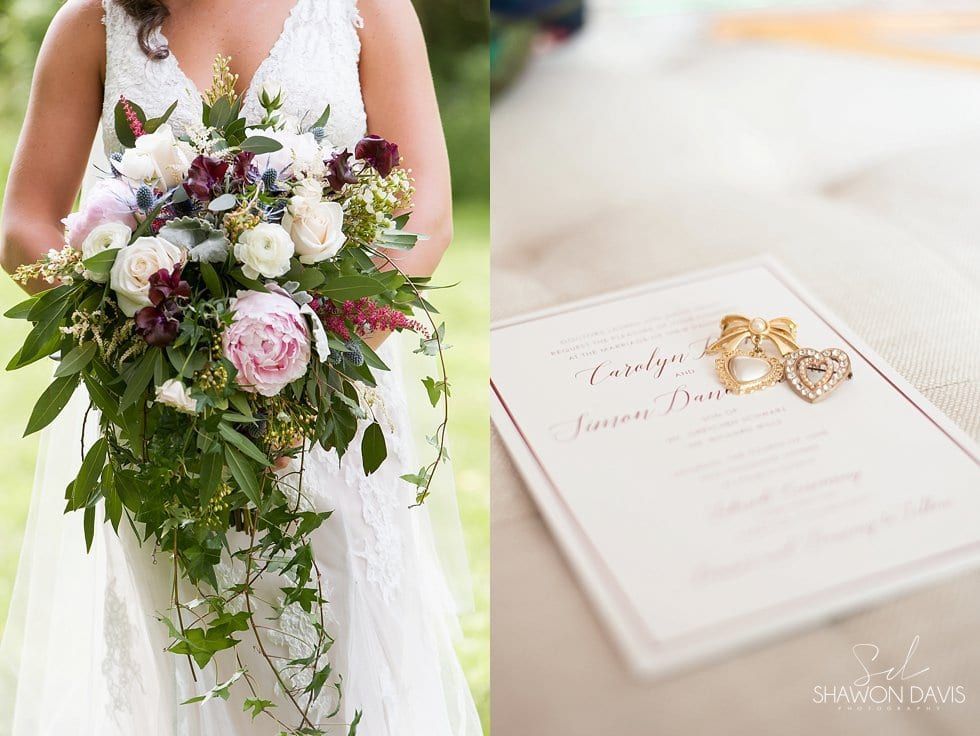 Bride holding a cascading bouquet beside a wedding invitation and rings