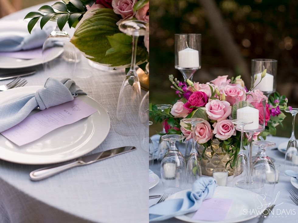 Elegant wedding table setting with pink rose centerpiece, white plates, candles, and folded lilac napkins