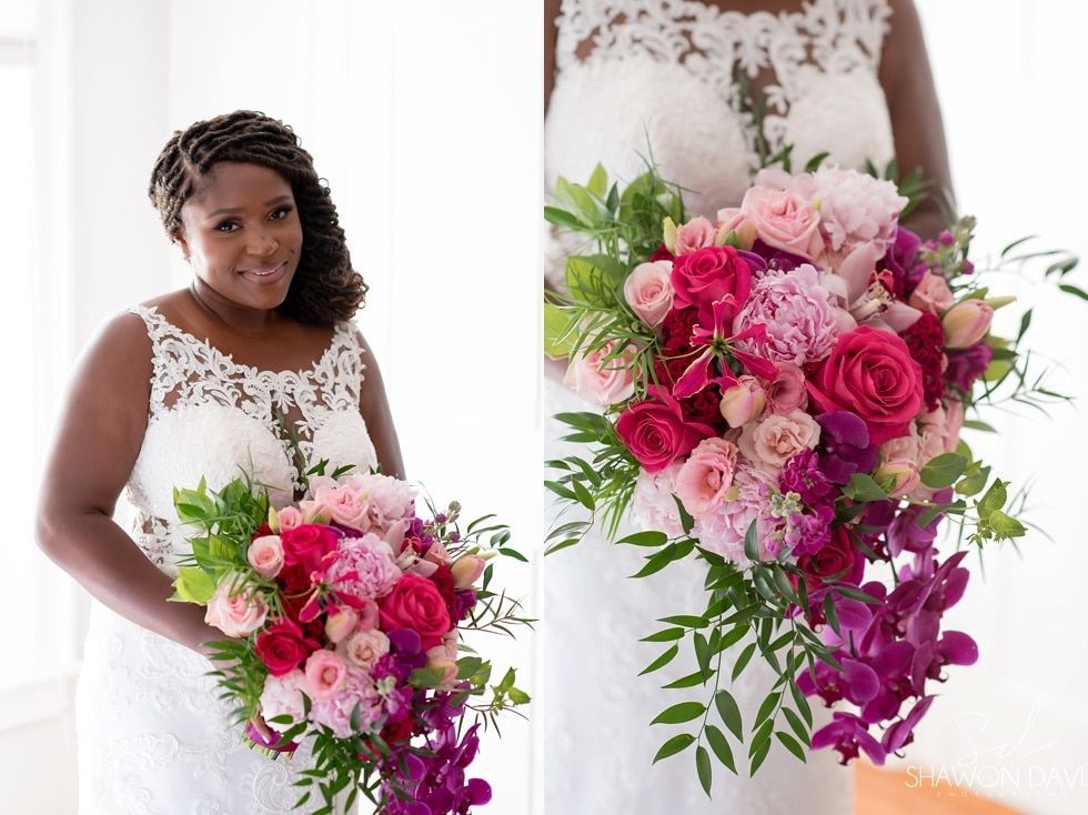 Bride holding a pink and purple bouquet in a white lace wedding dress
