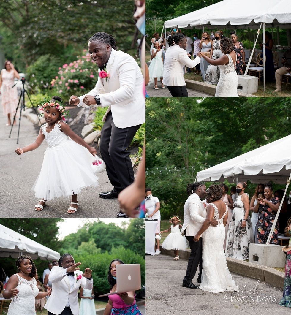 Wedding couple dancing outdoors under a white tent, with guests watching and cheering in a garden.