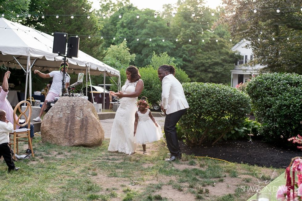 Bride and groom dancing outdoors at a garden wedding under trees and tents