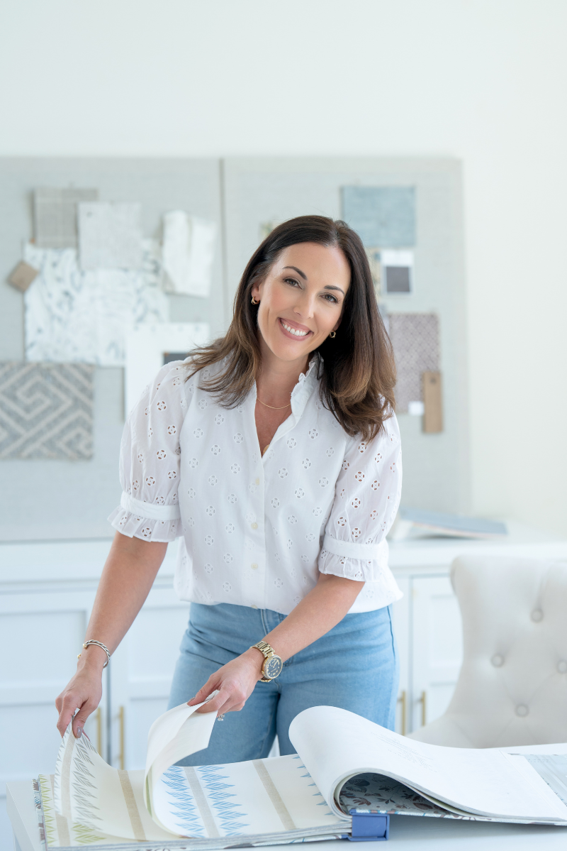 Woman in a white shirt flipping through pages of an interior designer fabric swatch book