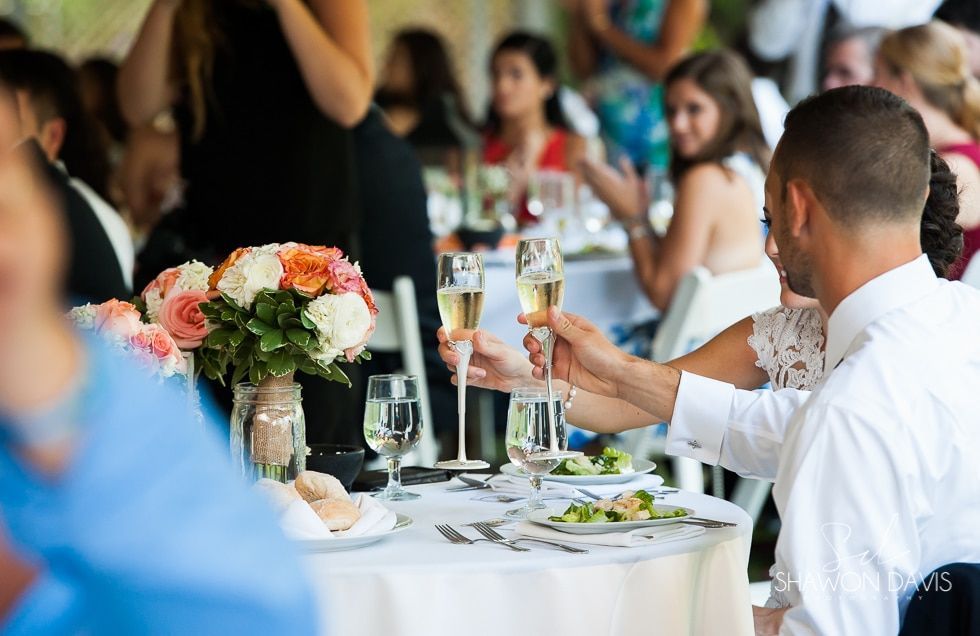 People toasting at a formal banquet table with flowers and wine glasses