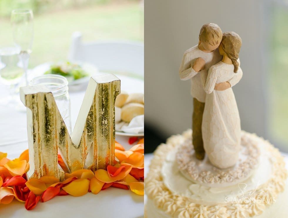 Wedding decor with wooden initials on autumn leaves and a bride-and-groom cake topper on a white cake