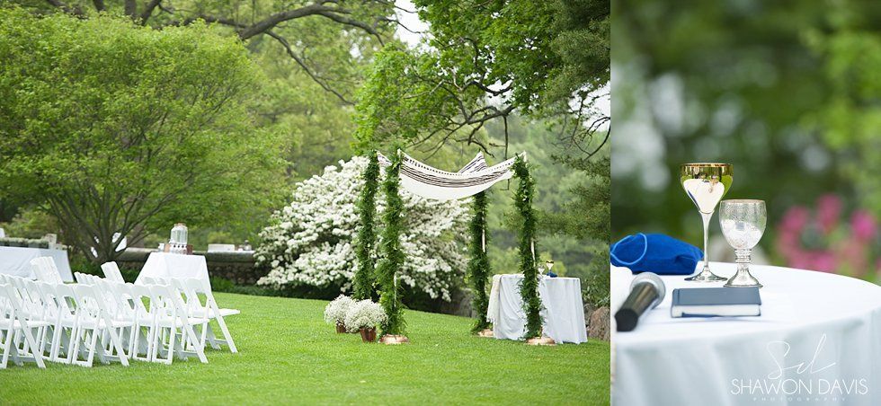 Outdoor wedding setup with white chairs, floral arch, and blue-accented tables on a green lawn