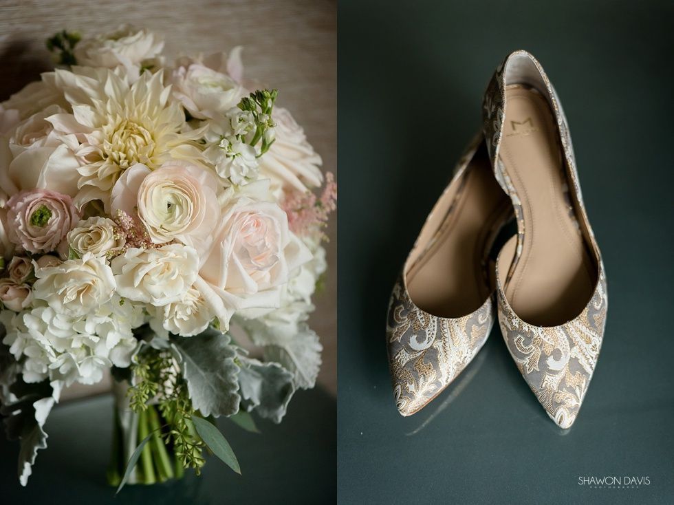 Bridal bouquet of white and blush flowers beside silver lace flats on a dark background
