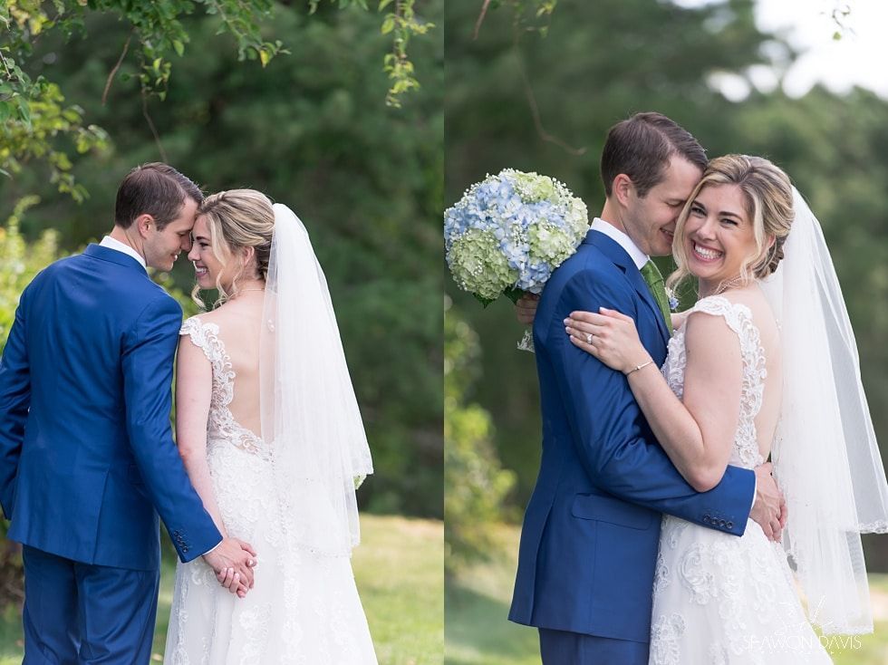 Two brides and two grooms in blue and white wedding attire sharing a kiss outdoors by greenery