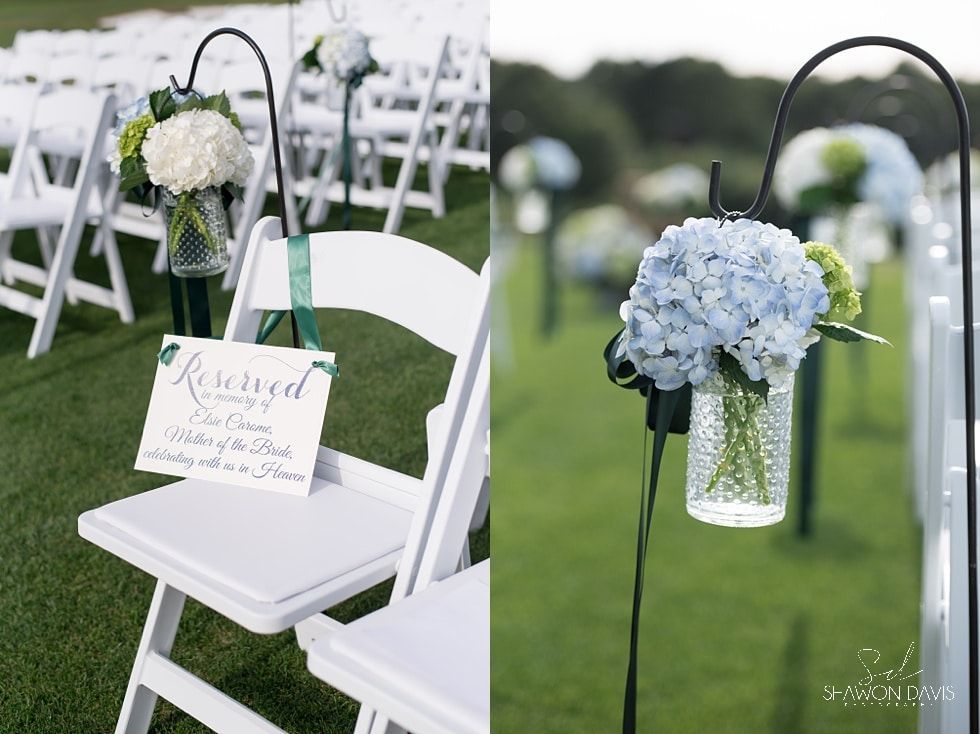 White chairs with blue and white flower arrangements at an outdoor wedding ceremony