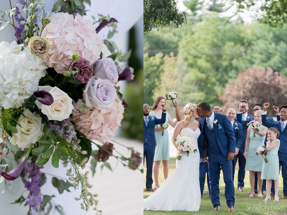 Wedding couple walking outdoors with guests, pastel floral arrangements in foreground