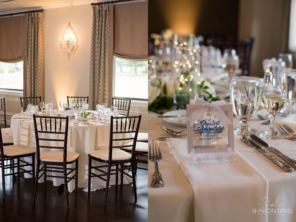 Elegant wedding reception table with white linens, black chairs, floral centerpieces, and glassware in a warm-lit hall