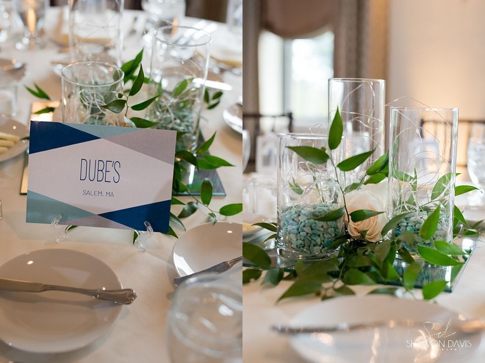 Elegant table setting with white plates, green foliage, and place cards at a formal event
