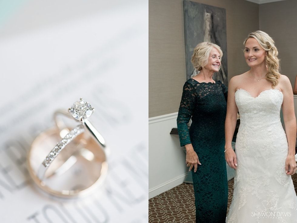 Wedding ring on display beside bride and woman in dark green dress at an indoor event