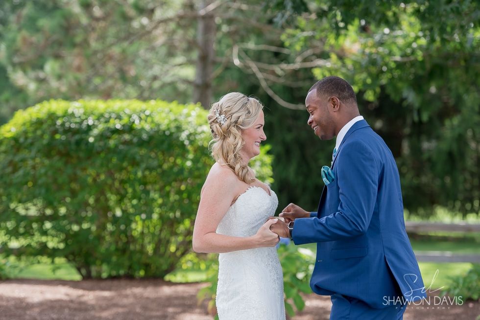 Bride and groom holding hands and smiling in a garden setting