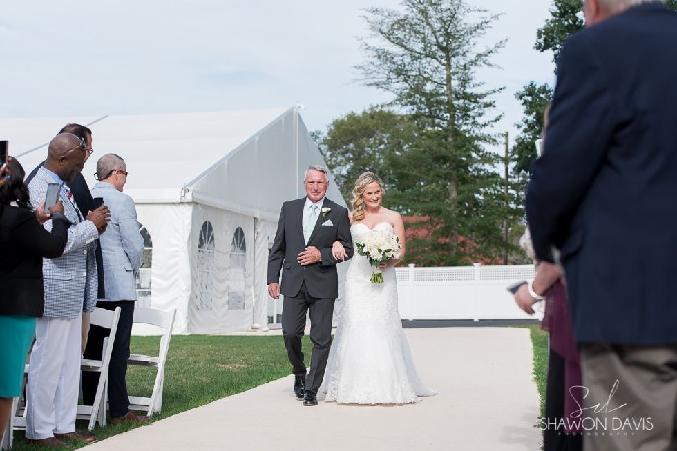 Bride and escort walking down an outdoor aisle at a wedding ceremony