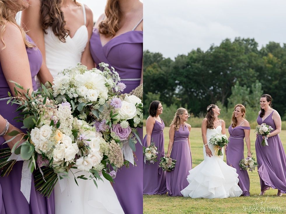 Bride and bridesmaids in lavender dresses holding bouquets in a grassy outdoor wedding setting