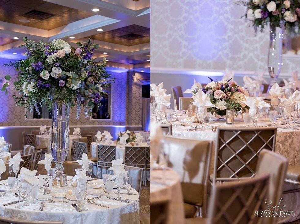 Elegant banquet hall with white and gold tables, floral centerpieces, and blue-purple uplighting