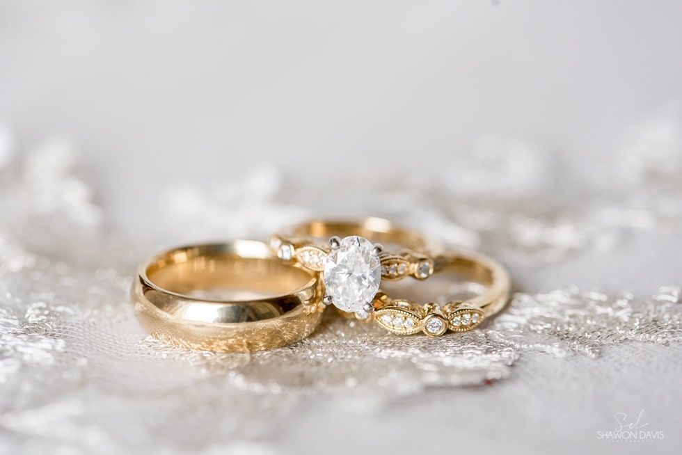 Gold wedding rings with a diamond on white lace fabric
