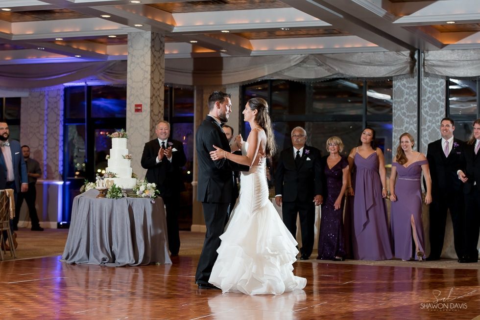 Bride and groom dancing at a wedding reception while guests watch
