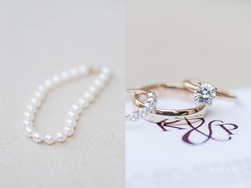 Pearl bracelet and diamond rings on a monogrammed card on a white surface