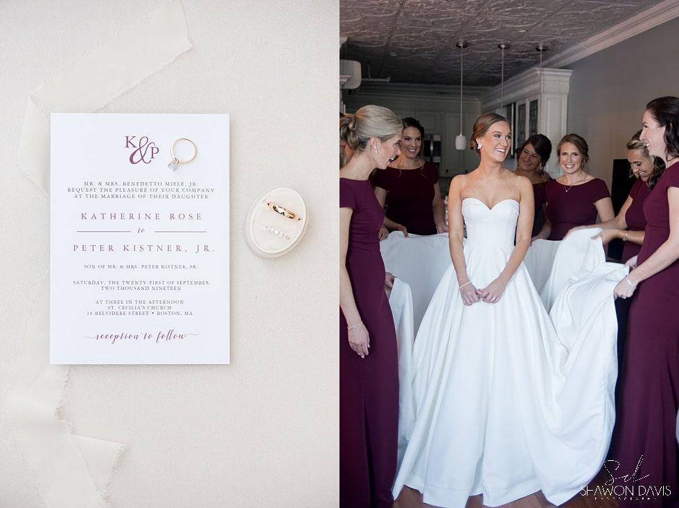 Bride in white dress with bridesmaids in burgundy beside wedding welcome sign