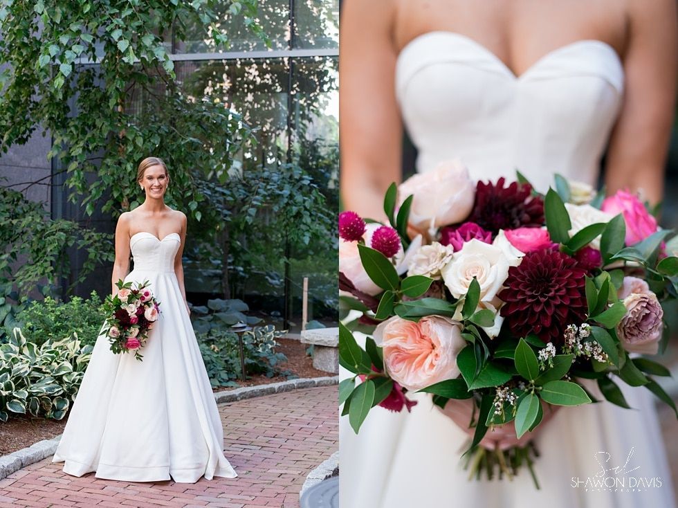 Bride in white gown holding a burgundy and blush bouquet outdoors in a garden ceremony scene