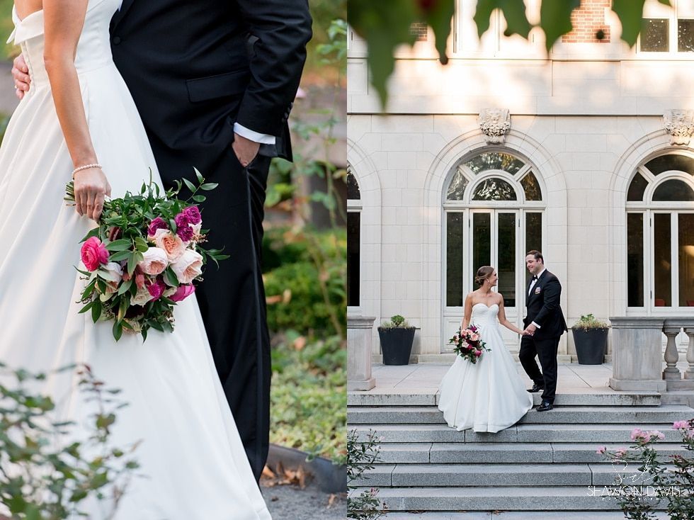 Bride and groom pose with bouquet in front of a white arched building.
