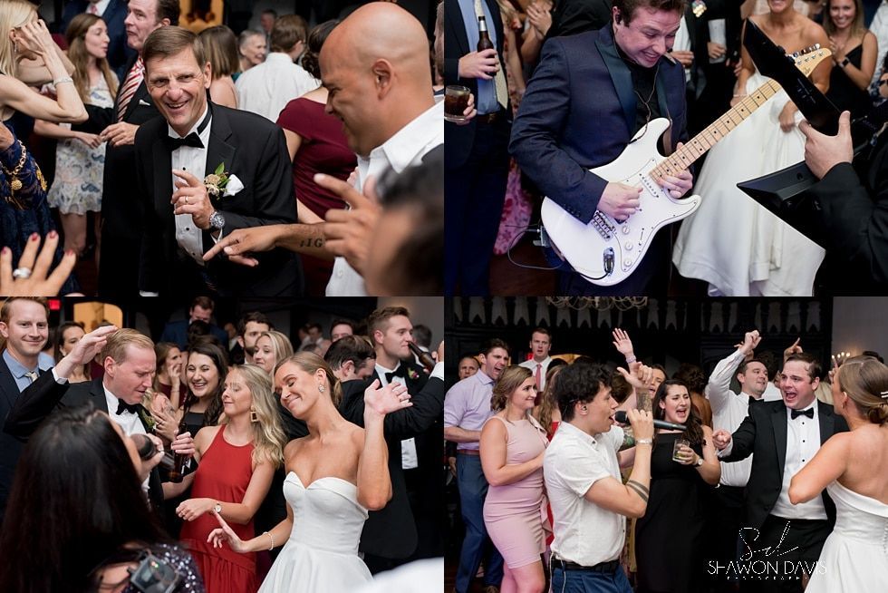 Crowded wedding reception with guests dancing, singing, and clapping in a lively hall